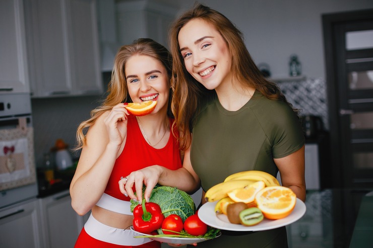 Two smiling women with fresh fruit and vegetables